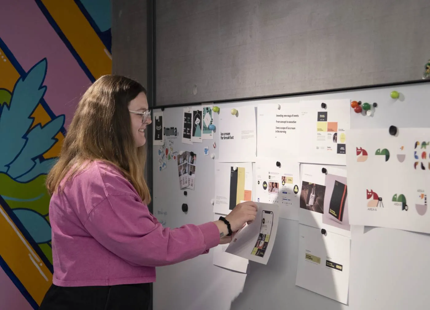 Branding specialist werkt aan een merkstrategie met visuele elementen en moodboard op een whiteboard.